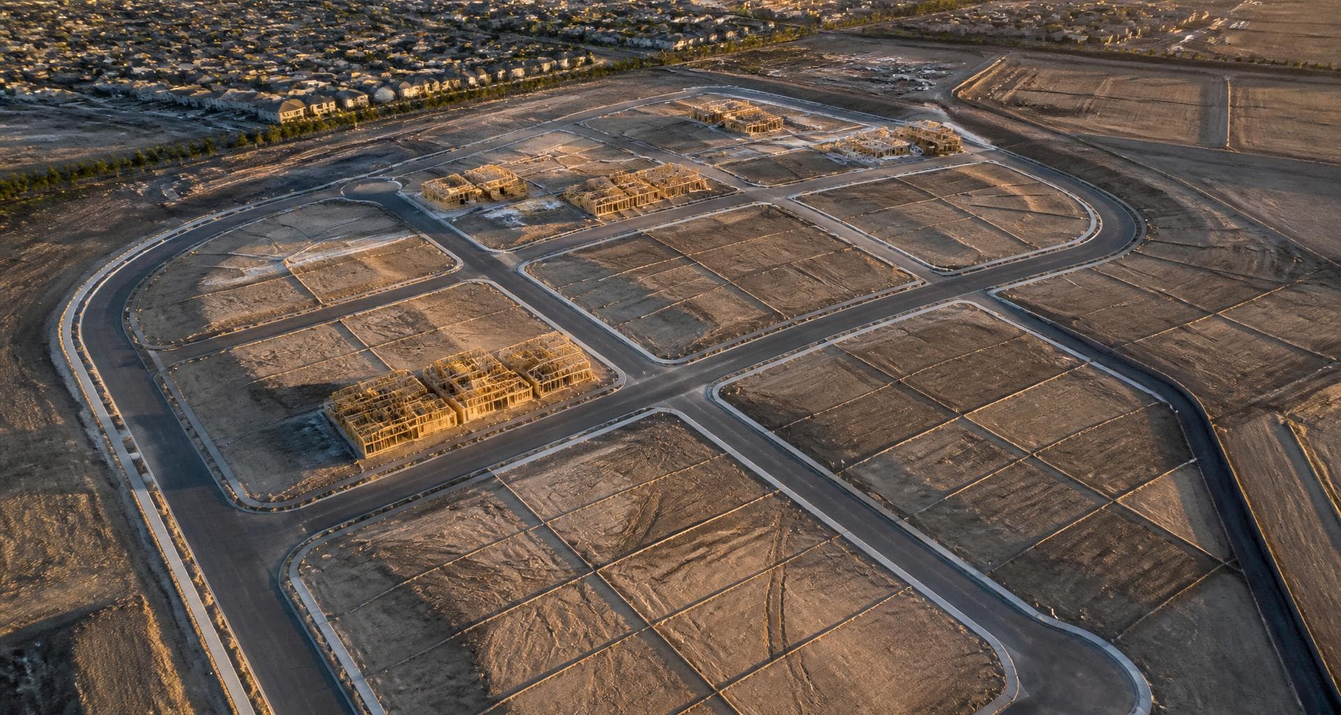 Aerial view of a residential subdivision under construction with graded lots
